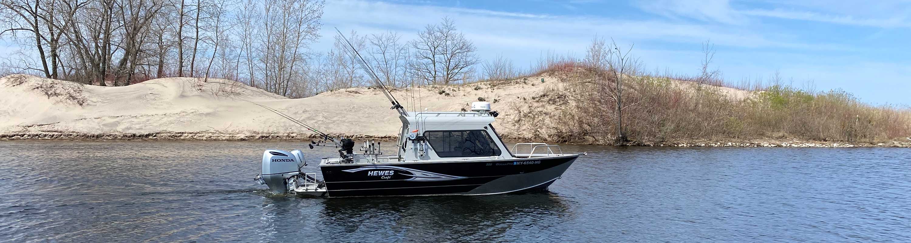 photo of the Hewes Craft going past sand dunes and heading out to Lake Ontario