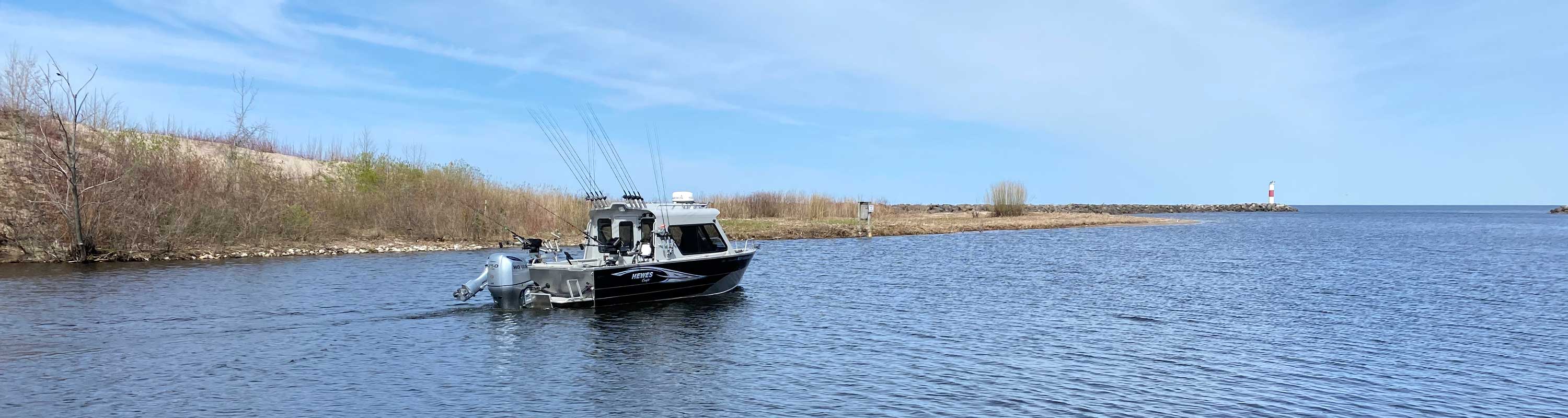Photo of the Hewes boat heading toward Lake Ontario from the Salmon River estuary