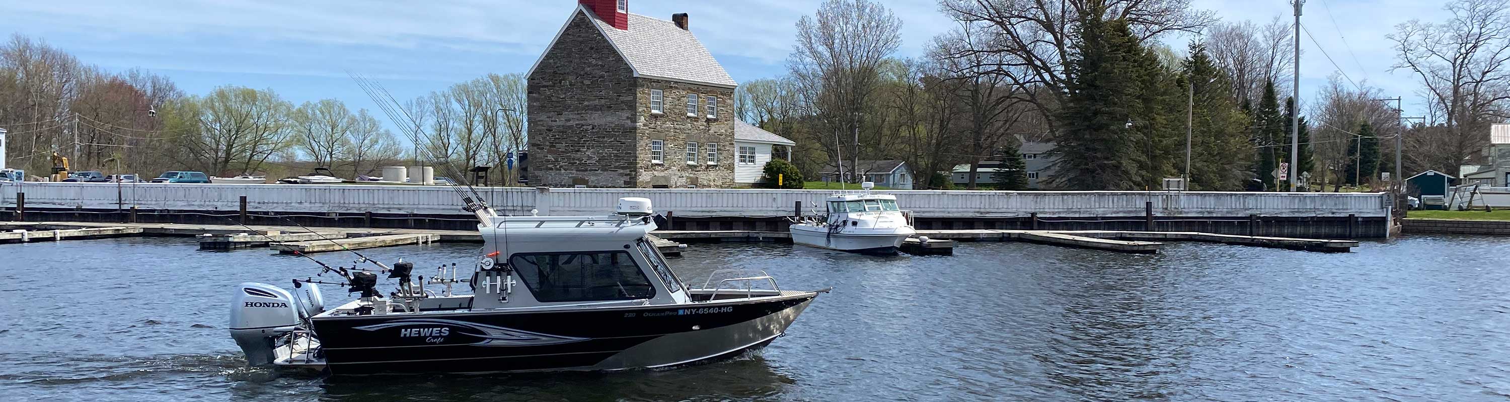 photo of the Hewes boat going past the lighthouse at Salmon River estuary