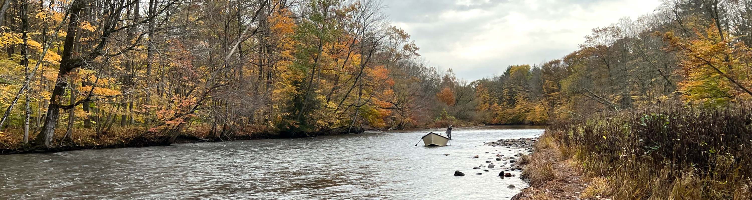 photo of Salmon River in the fall with a driftboat in the river